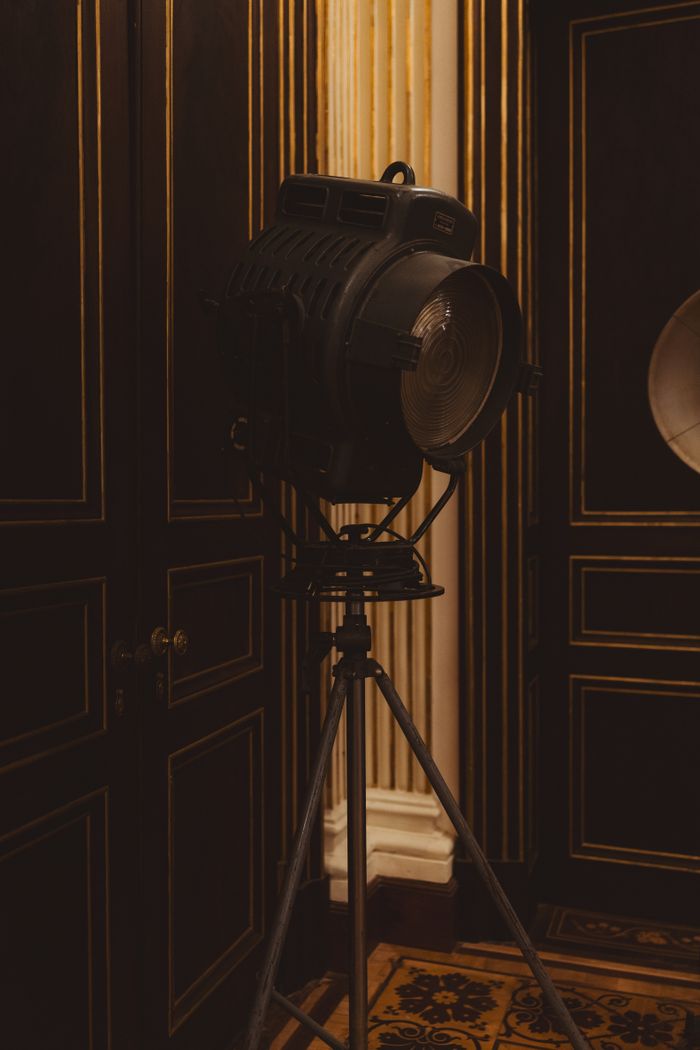 Classic vintage studio spotlight in a luxurious, ornate room with dark wood paneling.